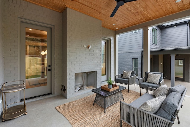 view of patio with ceiling fan and an outdoor living space with a fireplace