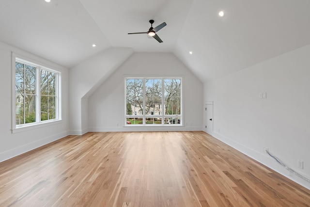 additional living space featuring baseboards, light wood-type flooring, lofted ceiling, and a ceiling fan