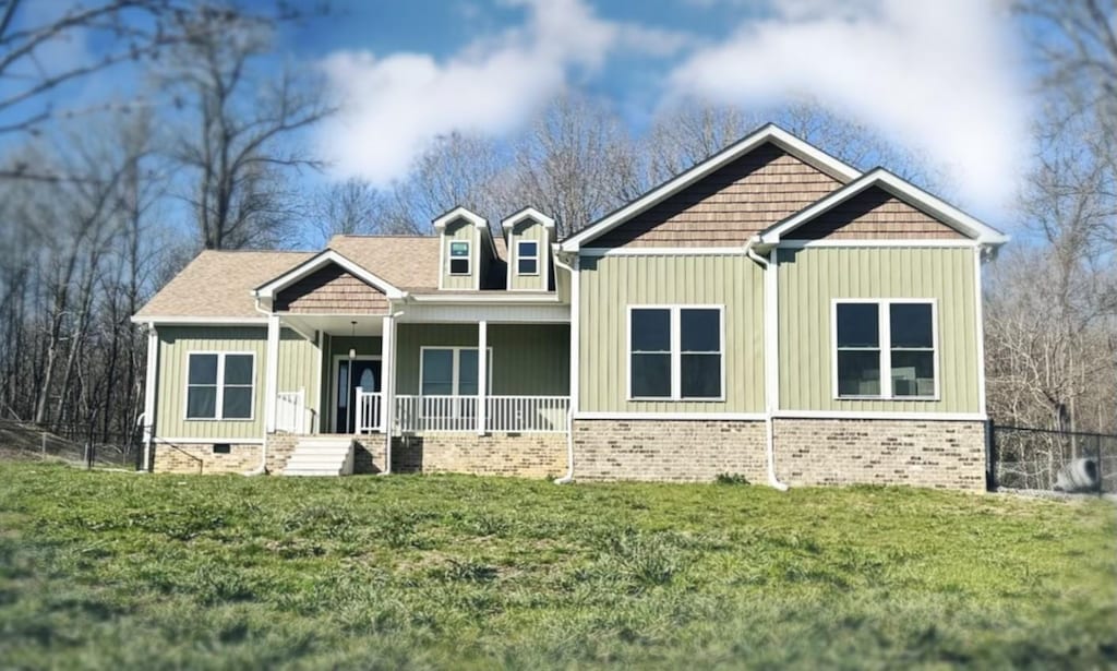 craftsman house with crawl space, brick siding, a porch, and a front yard