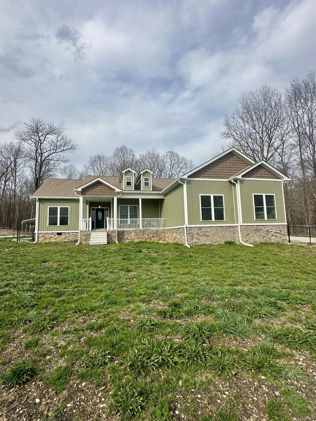 craftsman inspired home featuring covered porch, a front lawn, and fence