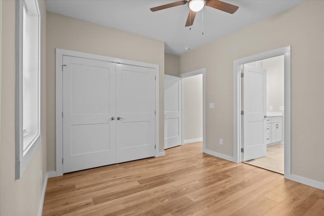 unfurnished bedroom featuring light wood-style floors, baseboards, ensuite bathroom, and a closet
