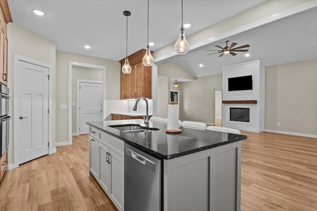kitchen featuring stainless steel appliances, a sink, a kitchen island with sink, light wood-type flooring, and recessed lighting