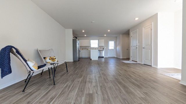 unfurnished room featuring recessed lighting, light wood-type flooring, and baseboards