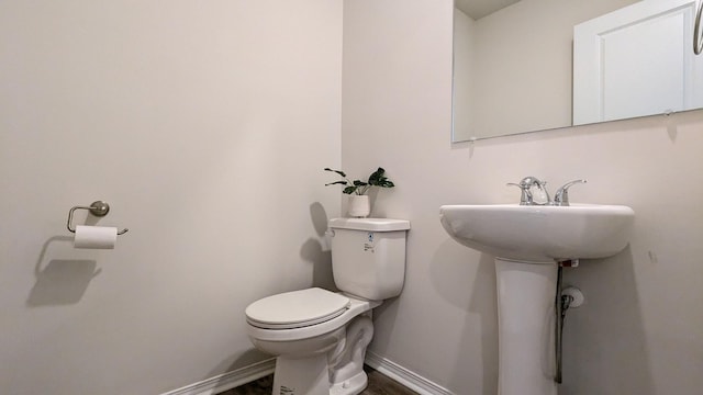 bathroom featuring toilet and baseboards