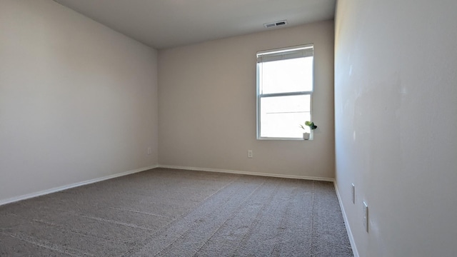 carpeted empty room featuring visible vents and baseboards