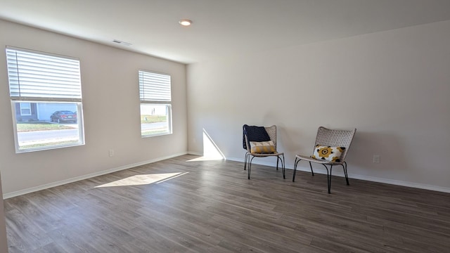 sitting room featuring visible vents, baseboards, and dark wood-style flooring