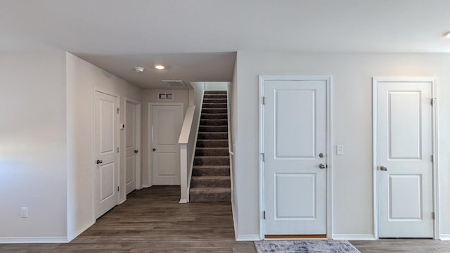 hall featuring visible vents, stairway, wood finished floors, and baseboards