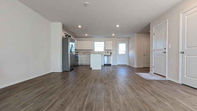 unfurnished living room featuring recessed lighting, baseboards, and wood finished floors