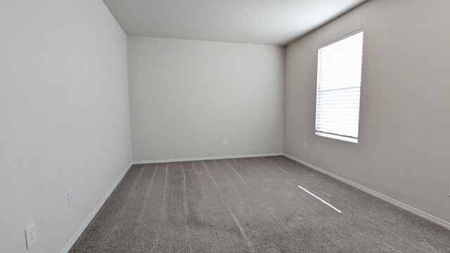 empty room featuring baseboards and carpet flooring