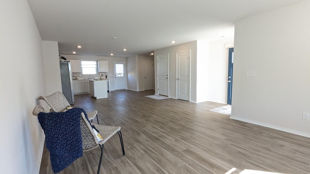 living area with recessed lighting, baseboards, and wood finished floors