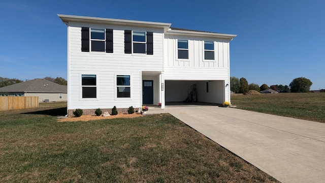 view of front facade with a front yard, concrete driveway, board and batten siding, and an attached garage