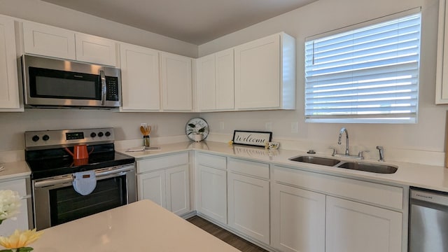 kitchen featuring light countertops, white cabinets, appliances with stainless steel finishes, and a sink