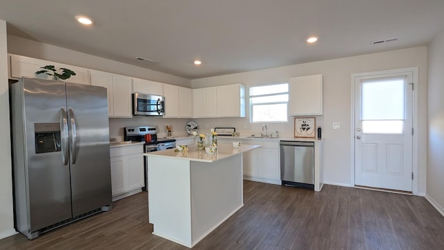 kitchen featuring dark wood-style flooring, a sink, light countertops, appliances with stainless steel finishes, and white cabinetry