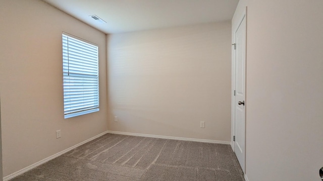 carpeted spare room with visible vents, a healthy amount of sunlight, and baseboards