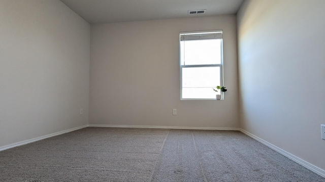 carpeted empty room featuring visible vents and baseboards