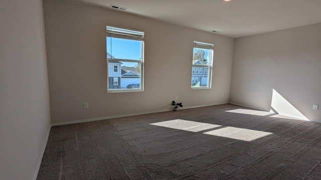 carpeted empty room with visible vents and baseboards