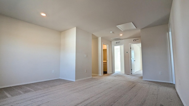 spare room with visible vents, baseboards, attic access, recessed lighting, and light carpet