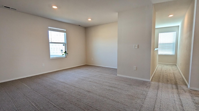 carpeted empty room with recessed lighting, visible vents, and baseboards