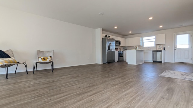 living area featuring recessed lighting, baseboards, and wood finished floors