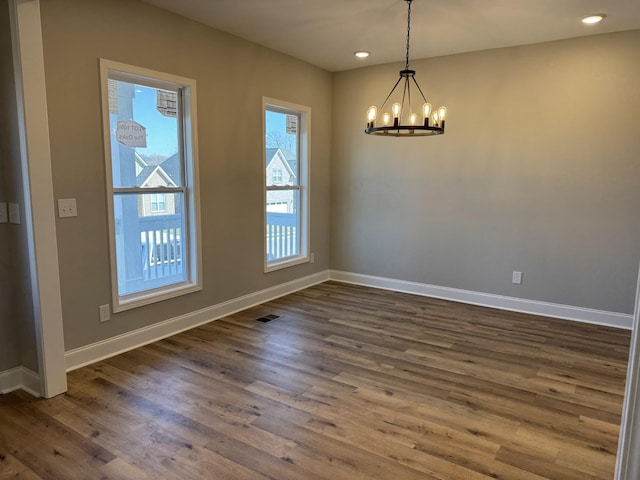 interior space featuring recessed lighting, baseboards, an inviting chandelier, and dark wood-style flooring