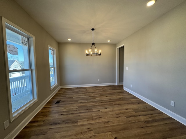 unfurnished dining area with visible vents, baseboards, an inviting chandelier, recessed lighting, and dark wood-style flooring