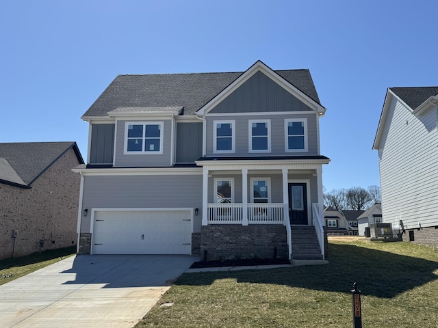 craftsman house featuring board and batten siding, a porch, a front yard, driveway, and an attached garage