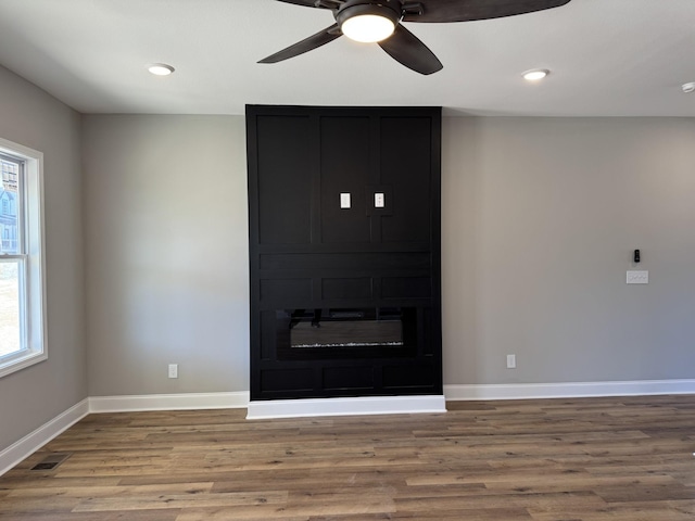 unfurnished living room with visible vents, wood finished floors, recessed lighting, baseboards, and ceiling fan