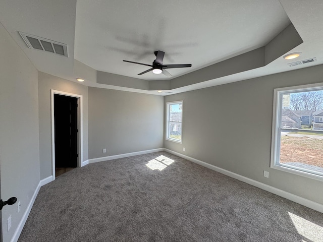 spare room with carpet flooring, baseboards, and visible vents