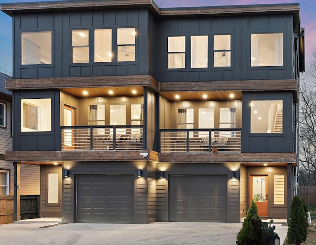 view of front of property featuring a balcony, board and batten siding, concrete driveway, and a garage