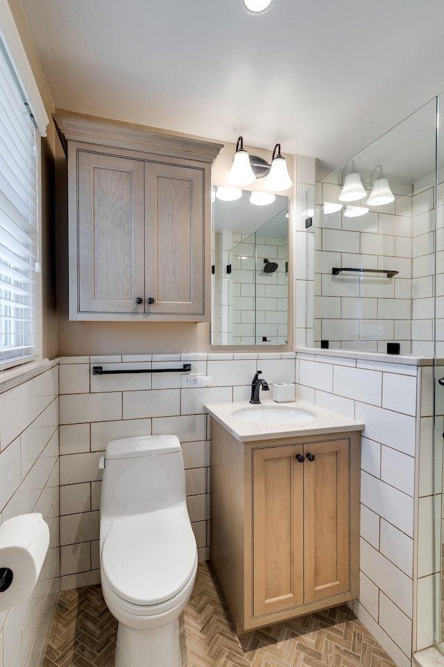 bathroom with toilet, a stall shower, tile walls, and vanity