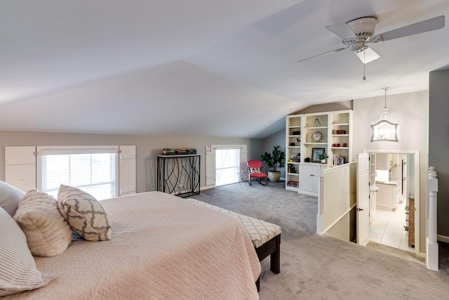 carpeted bedroom with ceiling fan, lofted ceiling, and ensuite bath