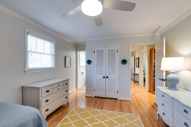 bedroom with light wood-type flooring, a ceiling fan, a closet, crown molding, and baseboards