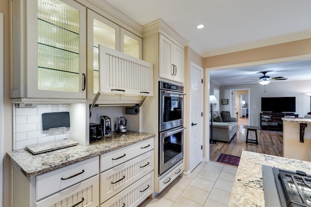 kitchen featuring ornamental molding, decorative backsplash, open floor plan, stainless steel double oven, and glass insert cabinets