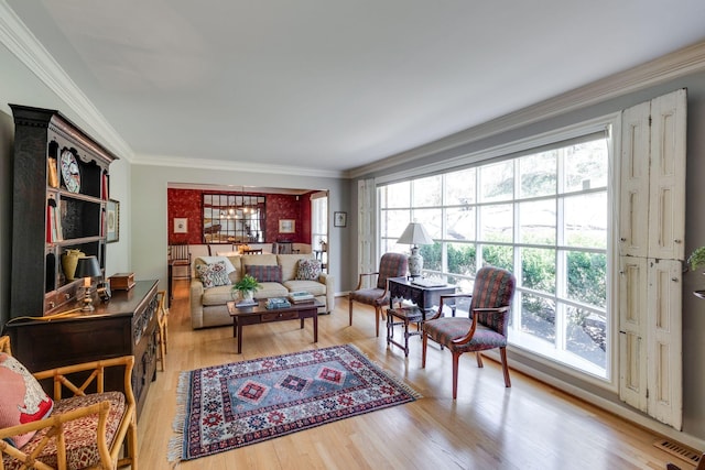 living area featuring visible vents, light wood-style flooring, and crown molding