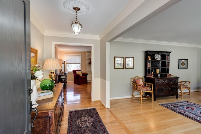 foyer with light wood-style flooring, baseboards, and ornamental molding