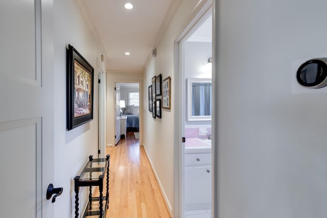 hall featuring crown molding, recessed lighting, light wood-type flooring, and baseboards