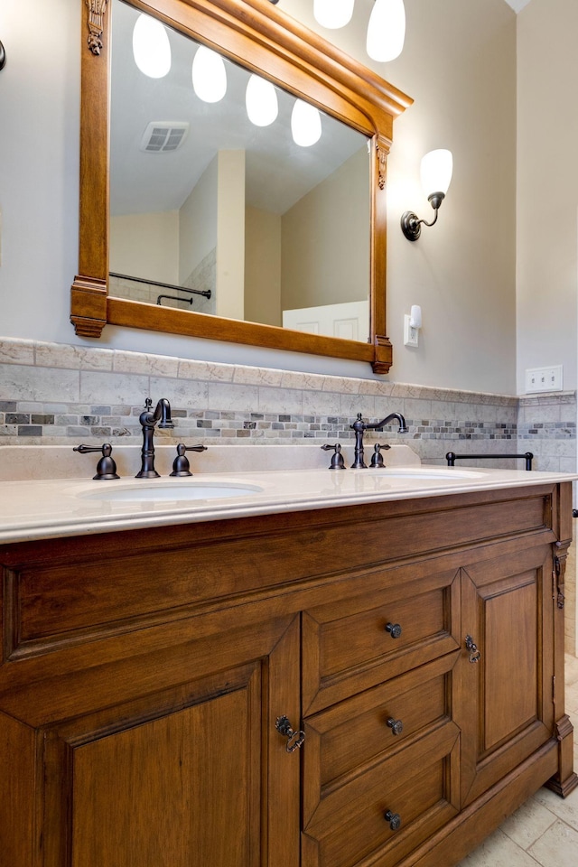 bathroom with tile patterned flooring, double vanity, visible vents, and a sink