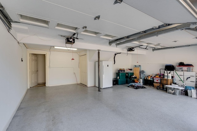 garage with a garage door opener and freestanding refrigerator