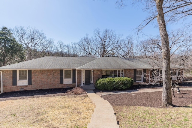 ranch-style home with brick siding, crawl space, a shingled roof, and a front lawn