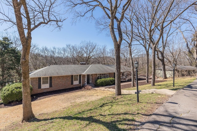 view of front of home with a front lawn and brick siding