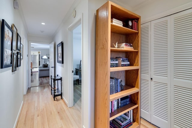 hallway featuring recessed lighting, baseboards, ornamental molding, and light wood finished floors