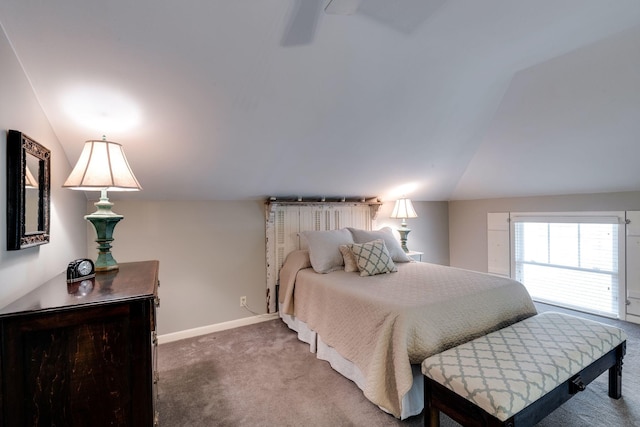 carpeted bedroom featuring vaulted ceiling and baseboards