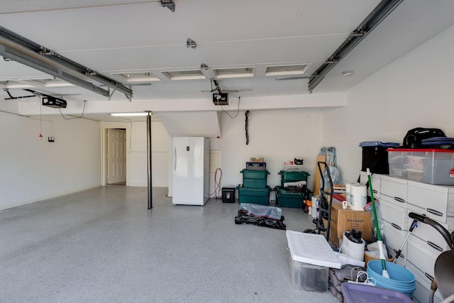 garage featuring a garage door opener and freestanding refrigerator