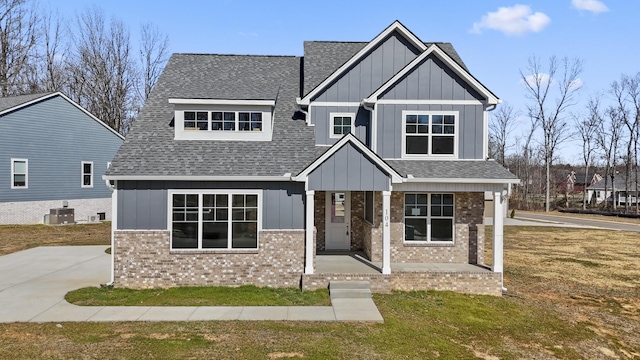 craftsman-style home featuring cooling unit, board and batten siding, and roof with shingles