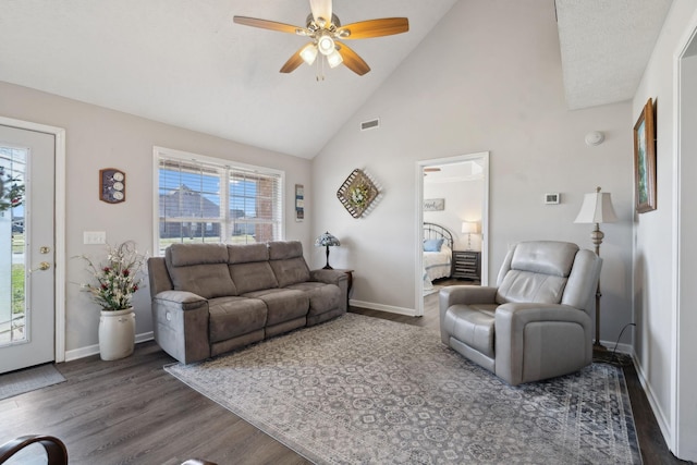 living room featuring visible vents, high vaulted ceiling, baseboards, and wood finished floors