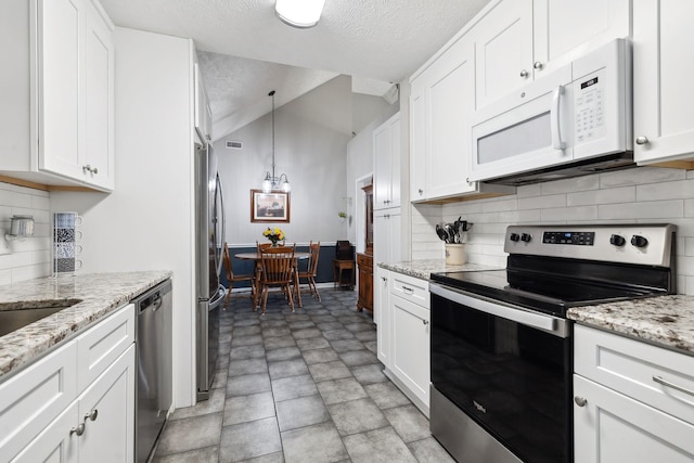 kitchen with a textured ceiling, backsplash, white cabinetry, appliances with stainless steel finishes, and lofted ceiling