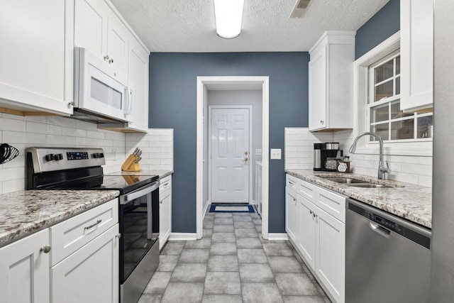 kitchen featuring a sink, stainless steel appliances, visible vents, and white cabinets