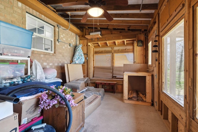 interior space featuring light carpet, brick wall, and a ceiling fan