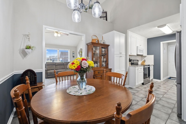 dining room with vaulted ceiling, baseboards, and ceiling fan