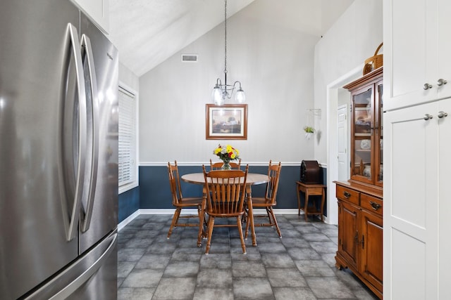 dining room with visible vents, baseboards, and vaulted ceiling